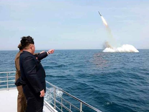 Lãnh đạo Triều Tiên Kim Jong-un chỉ tay vào một tên lửa đạn đạo được cho là phóng từ dưới nước. Ảnh: KCNA
