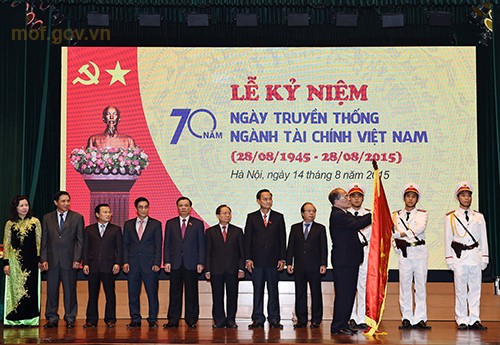 Chủ tịch Quốc hội Nguyễn Sinh Hùng gắn Huân chương Hồ Chí Minh lên lá cờ truyền thống ngành Tài chính.