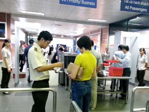 Nhân viên an ninh hàng không kiểm tra giấy tờ nhân thân hành khách đi máy