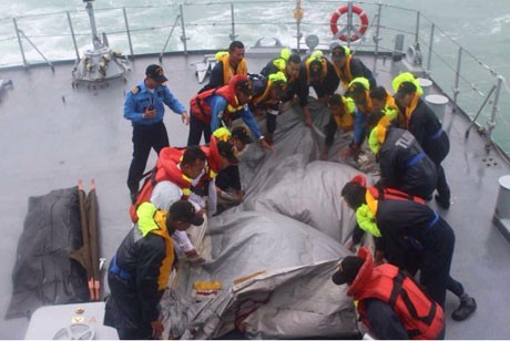 Các thành viên của đội cứu hộ trục vớt mảnh vỡ nghi là đuôi máy bay QZ8501 