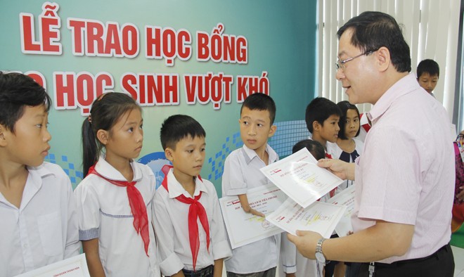Nhà báo Lê Xuân Sơn - Tổng biên tập báo Tiền Phong trao học bổng cho các học sinh.