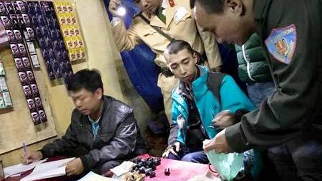 Nam thanh niên mặc áo khoác xanh, cùng các tang vật ở trên bàn liên quan đến hành vi mua bán chất ma túy bị công an bắt quả tang. Ảnh: Công an Huế