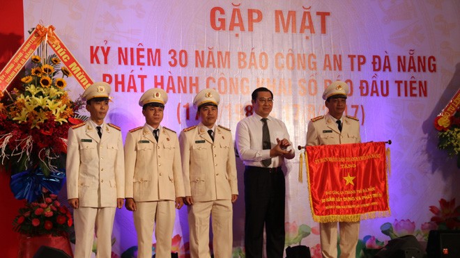  Ông Huỳnh Đức Thơ, Chủ tịch UBND TP Đà Nẵng, tặng cờ thi đua ghi nhận đóng góp của báo CATP ĐÀ Nẵng trong 30 năm qua. Ảnh Nguyễn Thành 