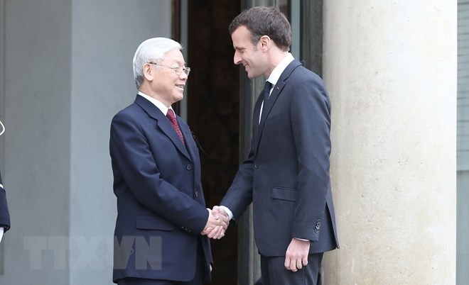 Tổng thống Cộng hòa Pháp Emmanuel Macron đón Tổng Bí thư Nguyễn Phú Trọng. (Ảnh: Trí Dũng/TTXVN)