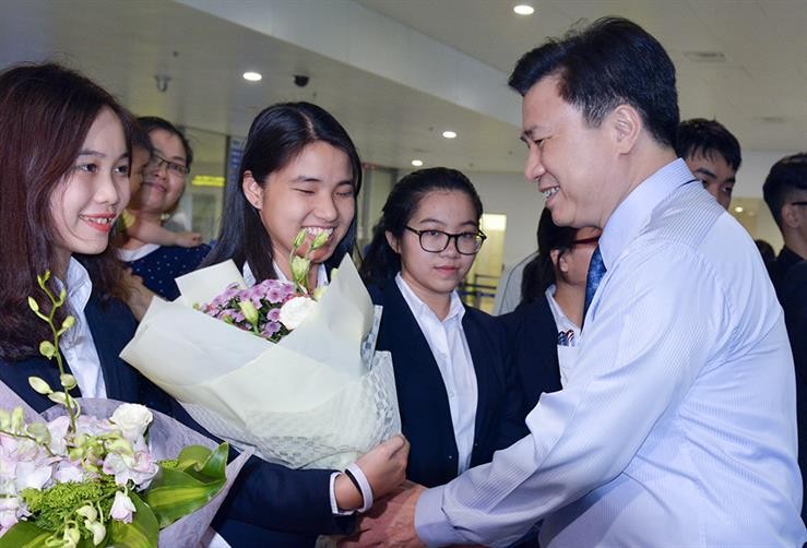 Thứ trưởng Bộ GD&ĐT Nguyễn Hữu Độ tặng hoa chúc mừng các thành viên trong đoàn dự thi trở về. 