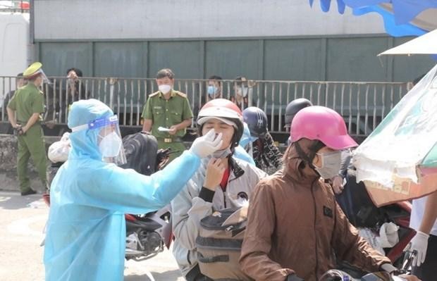 Tổ chức test nhanh COVID-19 cho người dân trước khi qua chốt kiểm soát để về quê tại khu vực Thị trấn Tân Túc, huyện Bình Chánh, Thành phố Hồ Chí Minh. (Ảnh: TTXVN phát)