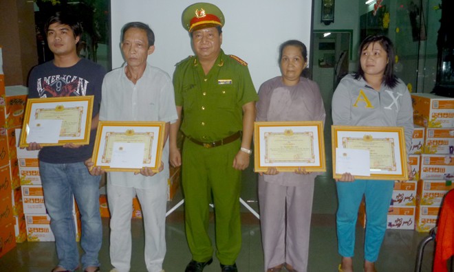 Thượng tá Đoàn Văn Thanh, Trưởng Công an thành phố Mỹ Tho trao tặng bằng khen của Ban Giám đốc Công an tỉnh Tiền Giang cho bà Trần Kim Liên (người đứng thứ 2 từ phải sang).