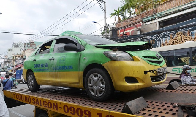Chiếc taxi bị cháy rụi phần đầu, được xe cứu hộ kéo đi khỏi hiện trường tránh tình trạng ùn ứ giao thông. Ảnh Văn Minh