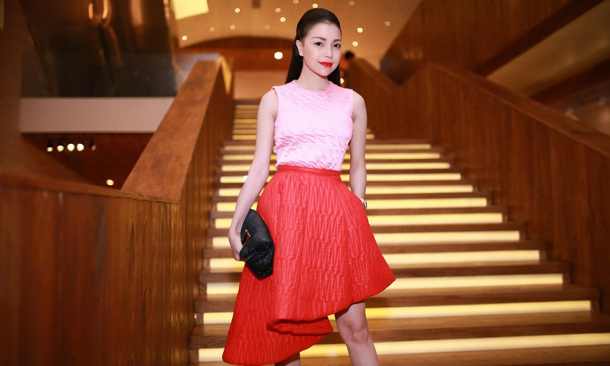 Người đẹp xuất hiện tại Tuần thời trang Quốc tế Việt Nam ngày thứ 2 với thiết kế gồm áo và váy màu hồng, chân đầm đỏ thuộc bộ sưu tập Thu Đông 2014 của thương hiệu Dior.
