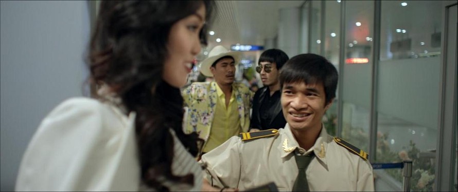 Hình ảnh của Lệ Rơi trong phim 'Sơn đẹp trai' với vai nhân viên an ninh ở sân bay.
