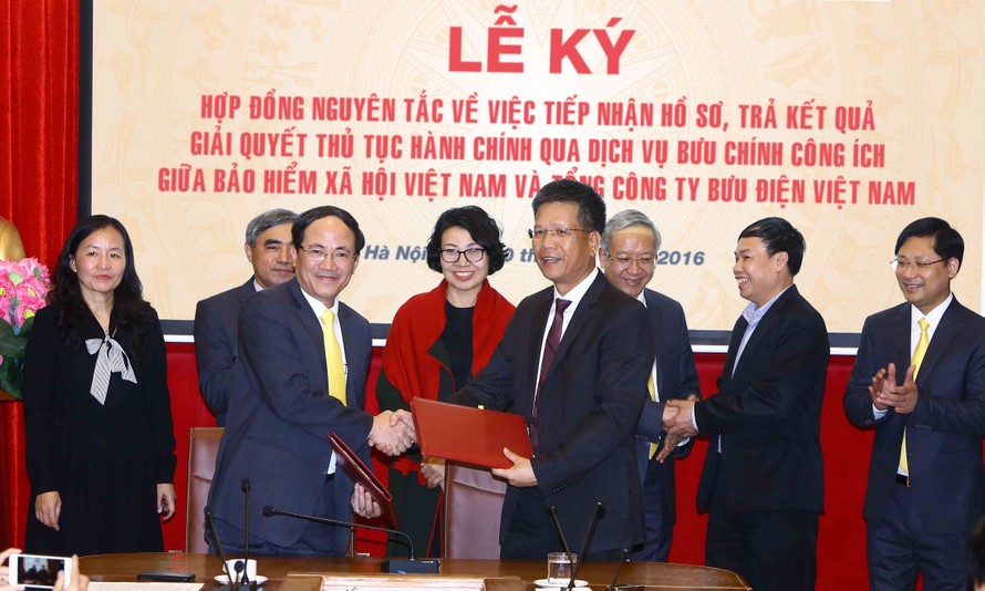 Phó Tổng giám đốc Bảo hiểm Xã hội Việt Nam Trần Đình Liệu và Tổng giám đốc Tổng công ty Bưu điện Việt Nam Phạm Anh Tuấn ký hợp đồng nguyên tắc.