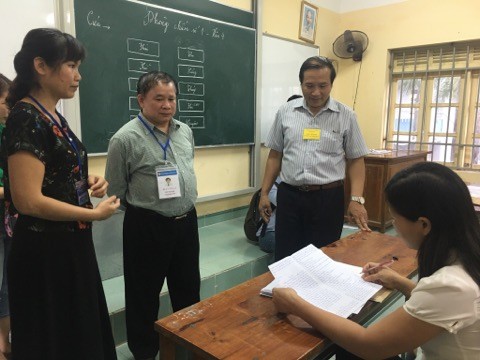 Thứ trưởng Bùi Văn Ga (người đeo thẻ đứng giữa) kiểm tra công tác chấm thi tại Hưng Yên