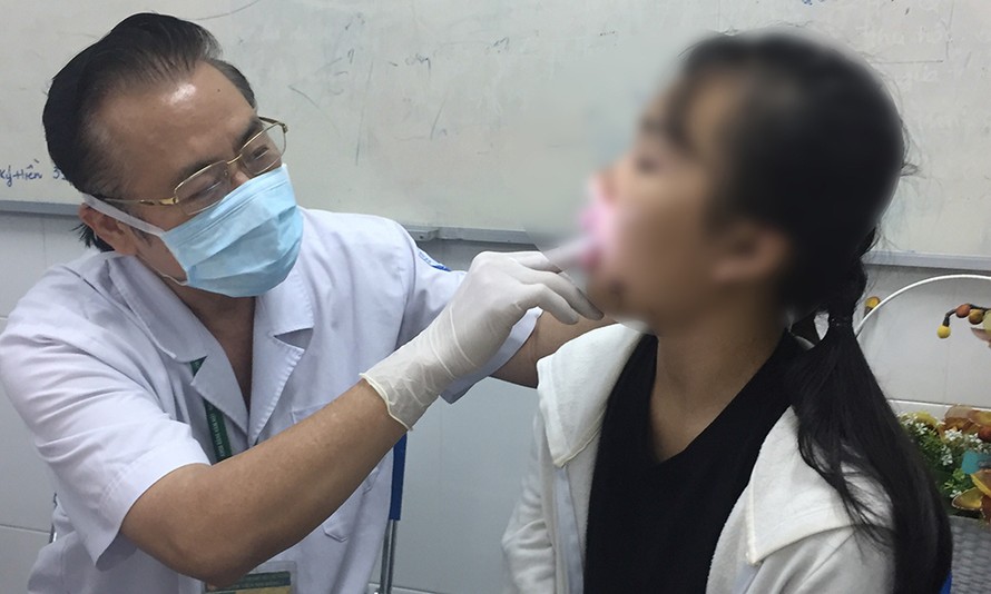 Bé Đ.L.P.T( 11 tuổi, ngụ Hóc Môn) đang được các bác sĩ thăm khám.