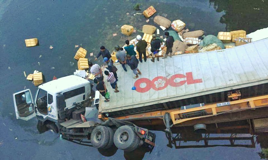 Ngay khi tai nạn xảy ra, hàng chục người dân tham gia trục vớt số hàng hóa bị bung ra khỏi thùng xe.