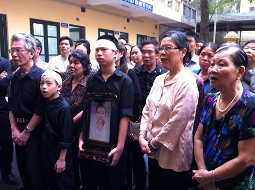 Hai con chị Huyền bên di ảnh mẹ trong phiên xử hồi tháng 4/2014