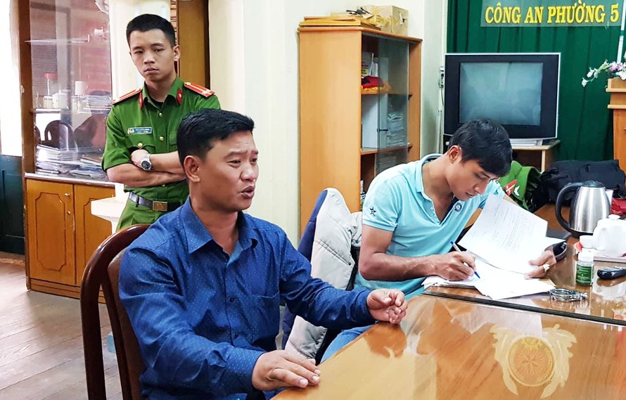 Nguyễn Quốc Dân (mặc áo sơ mi) tại cơ quan điều tra