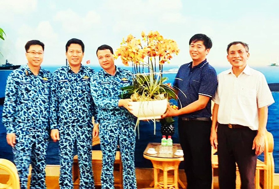 Anh Sang (áo xanh bên phải) tặng hoa lan cho bộ đội Trường Sa