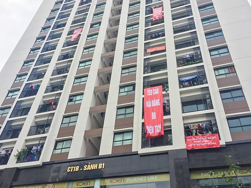 Cư dân căng băng rôn phản ứng về cách tính diện tích căn hộ tại Mon City.