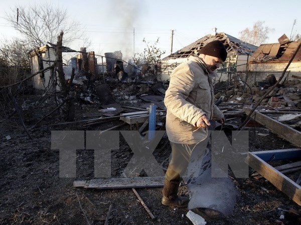 Người dân Ukraine thu dọn đống đổ nát. (Nguồn: AFP/TTXVN)