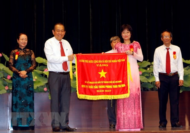 Phó Thủ tướng Thường trực Chính phủ Trương Hòa Bình tặng Cờ thi đua cho đại diện Sở Kế hoạch và Đầu tư Thành phố. (Ảnh:Hoàng Hải/TTXVN)