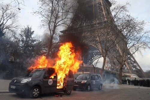 Xe quân sự chống khủng bố bị người biểu tình đốt gần Tháp Eiffel hôm 9/2. Ảnh: AFP