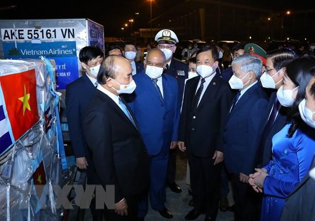 Chủ tịch nước Nguyễn Xuân Phúc với các đại biểu tại lễ tiếp nhận vắc-xin, thiết bị và vật tư y tế phòng, chống dịch COVID-19. (Ảnh: Nguyễn Điệp/TTXVN)