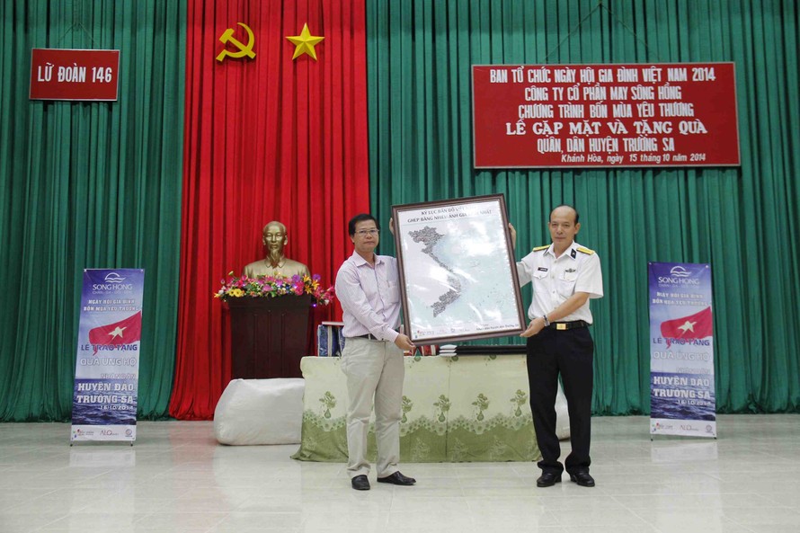 Ông Dương Văn Quynh - giám đốc Trung tâm triển lãm VHNT Việt Nam trao tặng bản sao thu nhỏ tấm bản đồ kỷ lục cho ông Nguyễn Văn Thắng- chính ủy lữ đoàn 146, vùng 4 hải quân.
