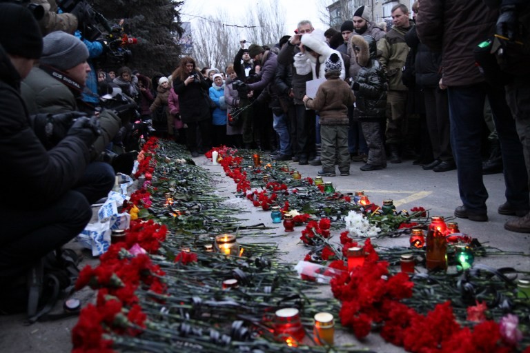 Mọi người trải hoa, thắp nến tại một trạm xe buýt ở Donetsk