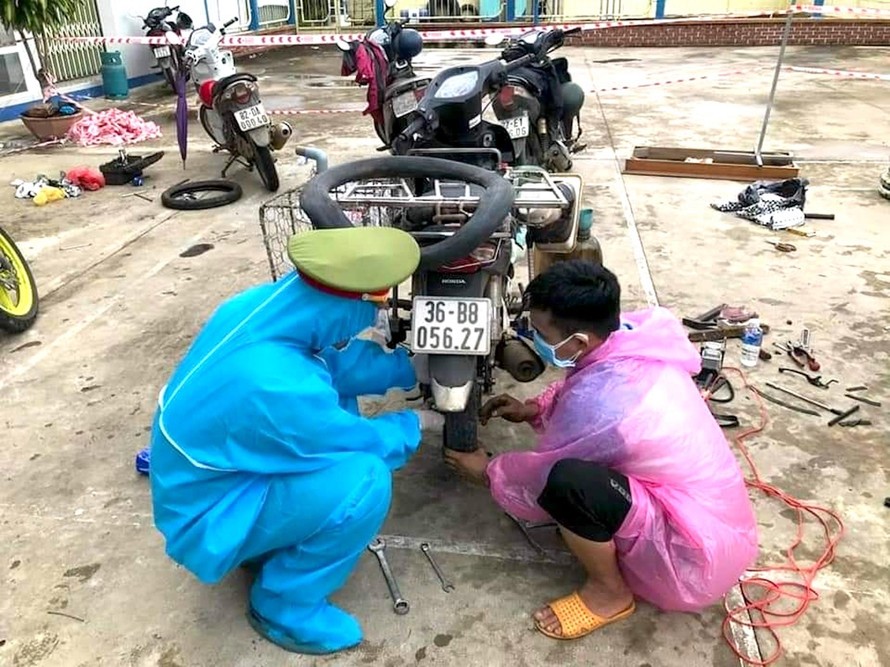 Các chiến sĩ Công an huyện Ngọc Hồi, Kon Tum sửa xe giúp người dân từ phía Nam về quê qua địa bàn