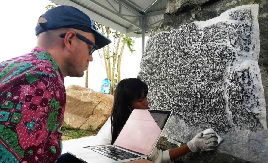 Giáo sư Arlo Griffiths và cộng sự nghiên cứu dòng chữ khắc trên bia đá (Ảnh: Nguyễn Quang Tuệ)