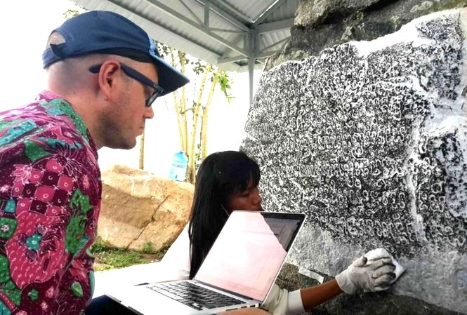 Giáo sư Arlo Griffiths nghiên cứu dòng chữ khắc trên bia đá Chăm Pa. Ảnh Nguyễn Quang Tuệ