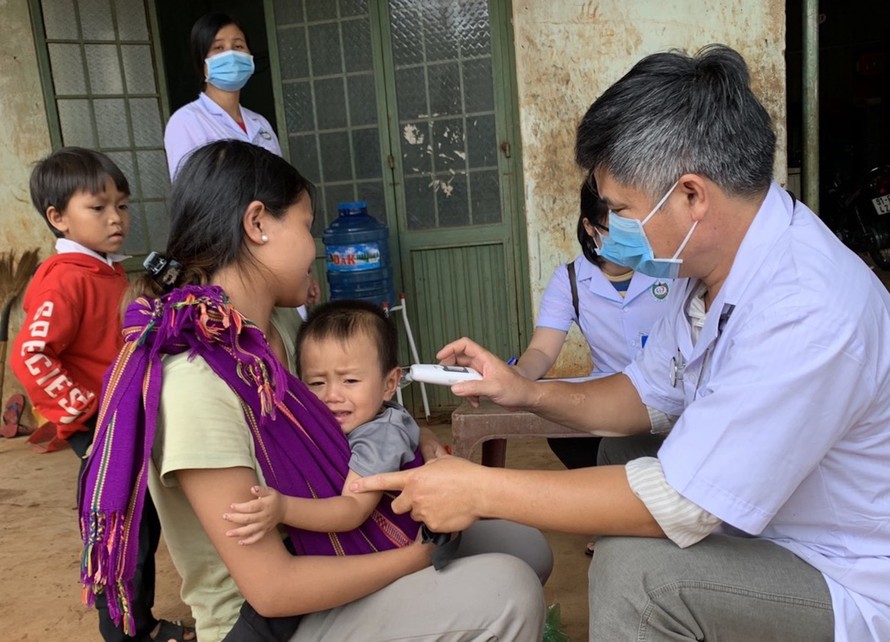 Bác sĩ kiểm tra thân nhiệt của các em nhỏ ở xã Hải Yang