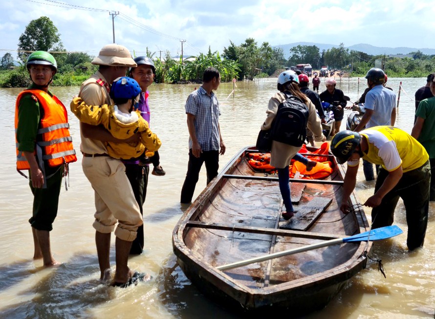 Cầu ở xã Ia Sao, thị xã Ayun Pa bị ngập nước, lực lượng chức năng hỗ trợ đưa người dân đi lại.