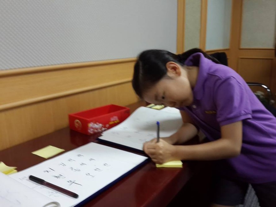 Một em nhỏ ghi sổ tang tại Đại sứ quán Hàn Quốc