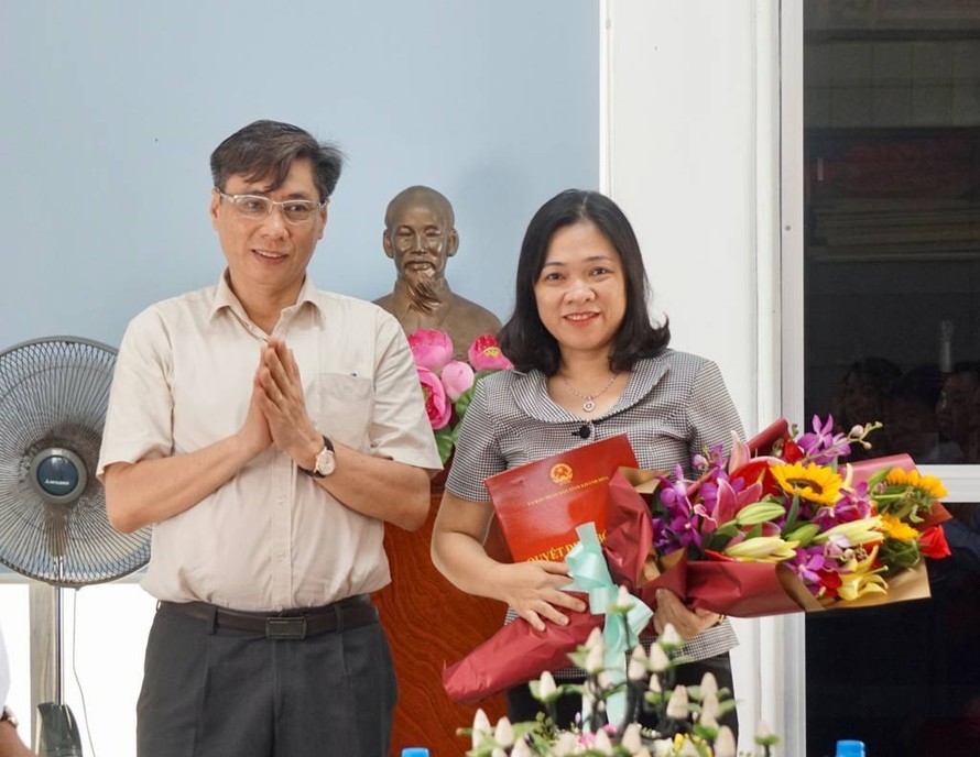 Ông Lê Đức Vinh trao quyết định bổ nhiệm và tặng hoa chúc mừng bà Trần Thu Mai (bên phải ảnh). Ảnh: Báo Khánh Hòa.
