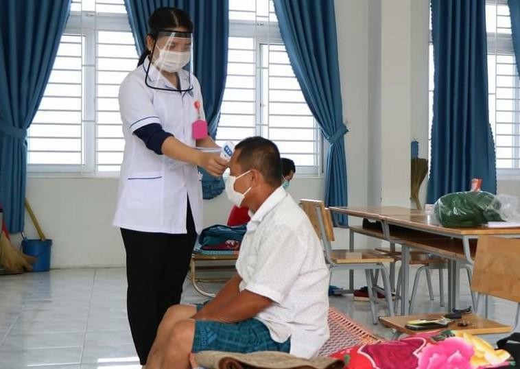 Nhân viên y tế Ninh Thuận kiểm tra thân nhiệt cho người dân trong khu cách ly. Ảnh: Lữ Hồ.
