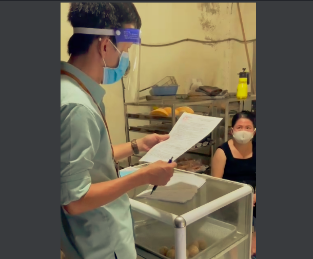Cán bộ phường Vĩnh Hoà đọc biên bản xử lý chủ cơ sở bánh mì ở đường Điện Biên Phủ, TP. Nha Trang. Ảnh chụp lại clip.