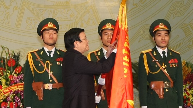 Chủ tịch nước Trương Tấn Sang gắn Huân chương Hồ Chí Minh lên Quân kỳ Quyết thắng của Tổng cục Chính trị, sáng 13/12.