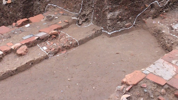 Hố khai quật khu vực Đoan Môn phát hiện nhiều dấu tích thời Lê: gạch vuông lớn lát trên nền sét vàng, móng trụ ngói, ba cống nước. Ảnh: T.Toan.