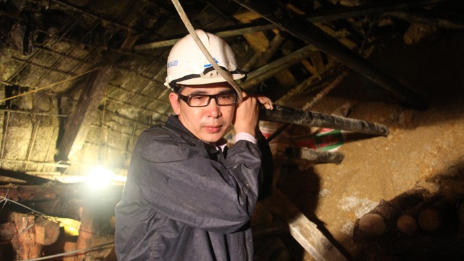 Ông Lưu Công Tới, đang nói chuyện với những nạn nhân mắc kẹt trong hầm sập qua ống sắt. Ảnh: Đại Dương.