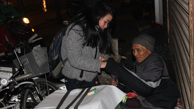 Tình nguyện viên tặng quà cho người vô gia cư.