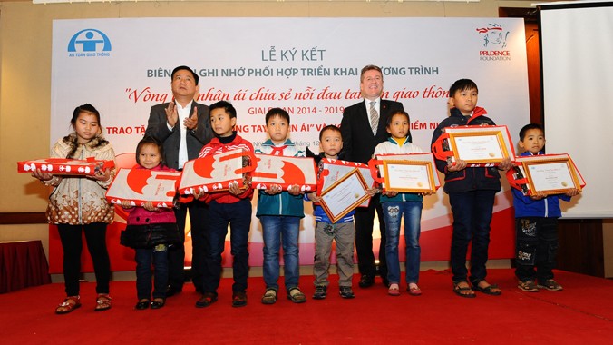Bộ trưởng Đinh La Thăng (trái, hàng sau) cùng các cháu bé có người thân bị mất vì tai nạn giao thông.