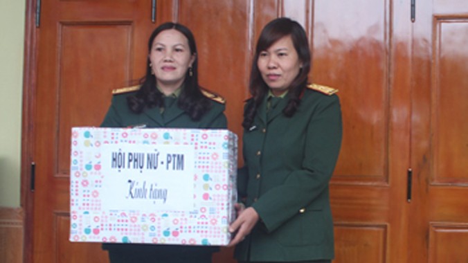 Đại diện Chi hội Phụ nữ Sư đoàn 324 tặng quà chị Sơn (trái) nhân dịp khánh thành nhà mới. Ảnh: Lê Tường Hiếu.