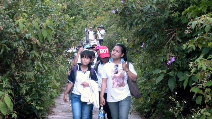 Trang (bên phải) trong một lần dẫn đoàn học sinh tiểu học quận Sơn Trà đi tìm hiểu các loài động vật ở rừng Sơn Trà. Ảnh: CTV.