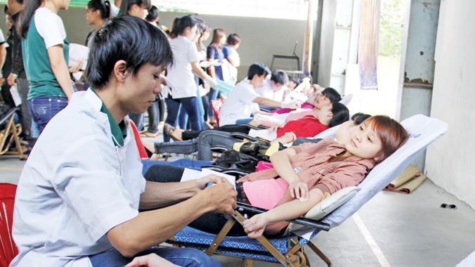 Hưởng ứng không khí của Chủ nhật Đỏ, sinh viên các trường ĐH, CĐ ở Đà Nẵng nhiệt tình tham gia hiến máu. (Trong ảnh: SV trường CĐ Thương mại tham gia hiến máu sáng qua, 31/1).
