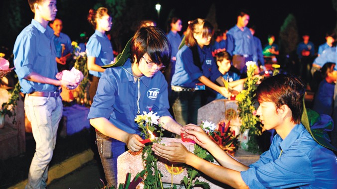 Thanh niên tình nguyện tham gia thắp nến tri ân tại nghĩa trang anh hùng liệt sĩ. Ảnh: Hồng Vĩnh.