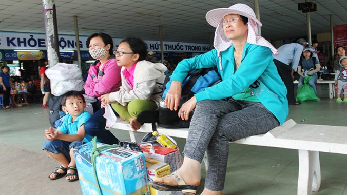 Bà Tăng Thanh Hiếu (đội nón) bắt xe khách từ Bình Phước về bến xe Miền Đông (TP.HCM) để về quê Cà Mau đón tết muộn. Ảnh: Việt Văn.