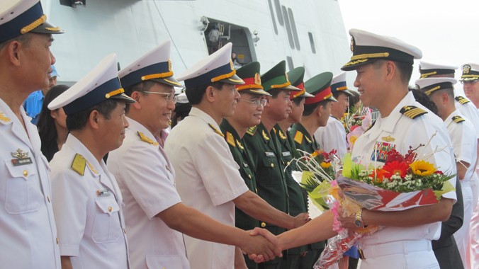 Đại tá Lê Bá Hùng (bên phải) bắt tay và nhận hoa từ Hải quân Việt Nam.