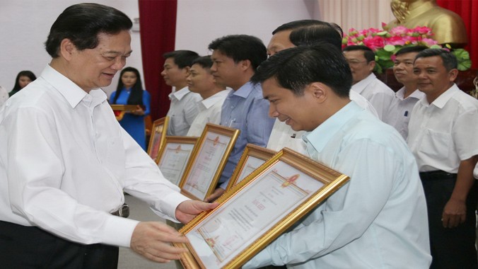 Thủ tướng Nguyễn Tấn Dũng trao bằng khen cho 5 tập thể, 11 cá nhân có thành tích trong xây dựng cụm tuyến dân cư vượt lũ. Ảnh: Hòa Hội.
