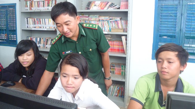 Thượng úy Bao Minh Tiến hướng dẫn các em tham gia “Lớp tin học cộng đồng Thiềng Liềng”.
